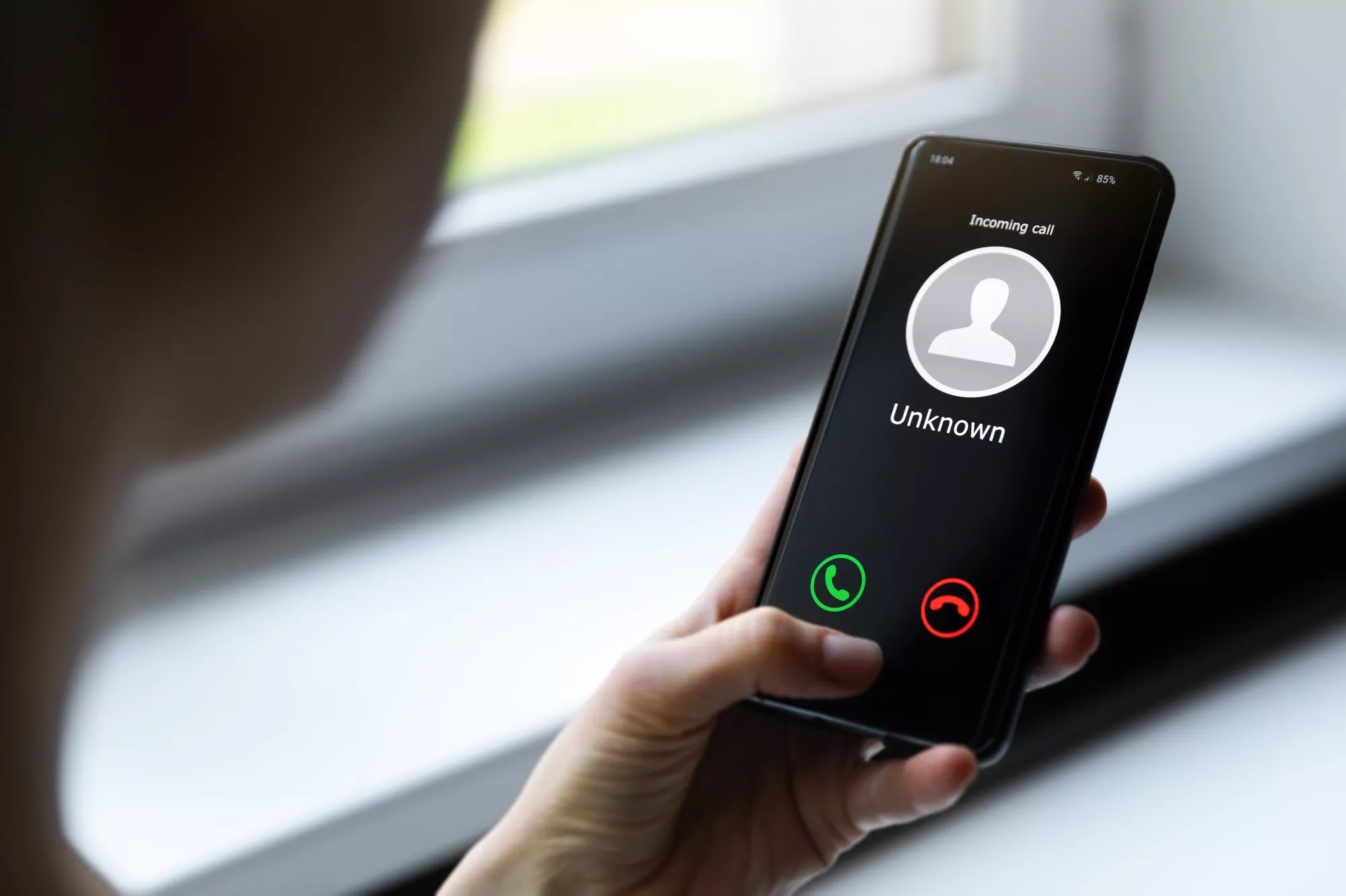Image of a cell phone being held with an unknown number calling. Image of a cell phone being held with an unknown number calling.