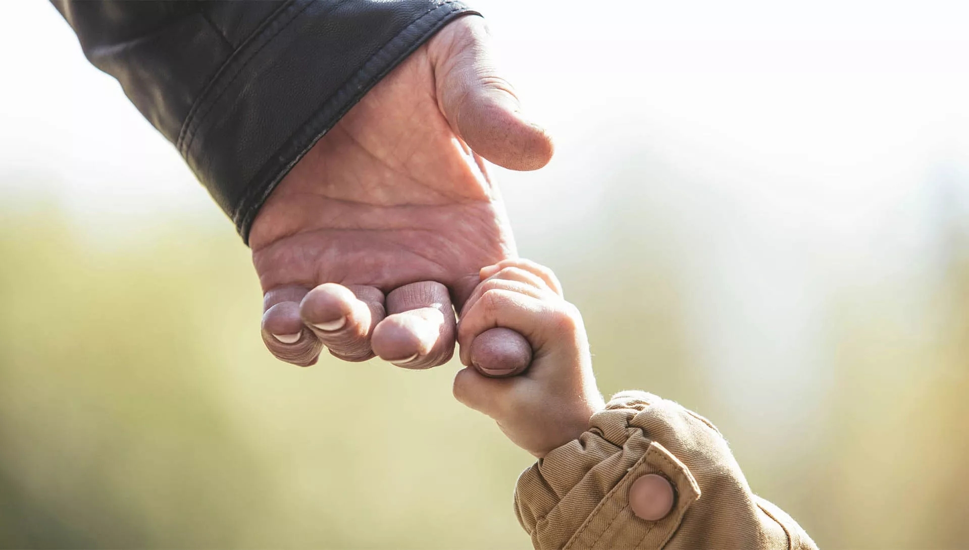 A child hand holding a man's index finger. A child hand holding a man's index finger.