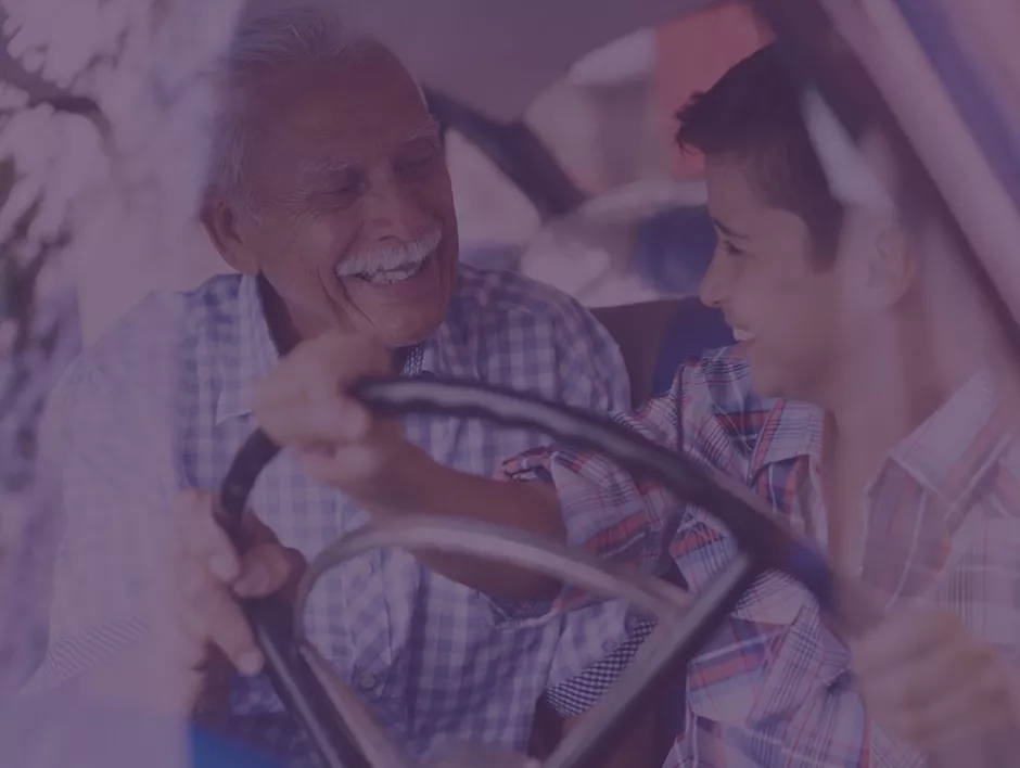 A grandfather teaching his grandson to drive a car. A grandfather teaching his grandson to drive a car.